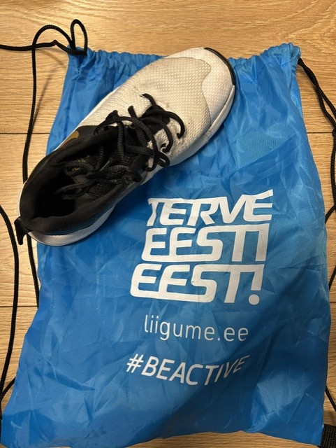 Valge spordijalats sinisel paeltega kotil, millel on kiri TERVE EESTI EEST!.